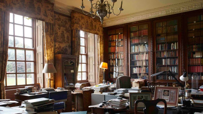 Tu mewn i stydi’r 7fed Ardalydd, gyda wal o silffoedd llyfrau a nifer o fyrddau ac arwynebau wedi eu gorchuddio â llyfrau a phapurau ym Mhlas Newydd, Ynys Môn